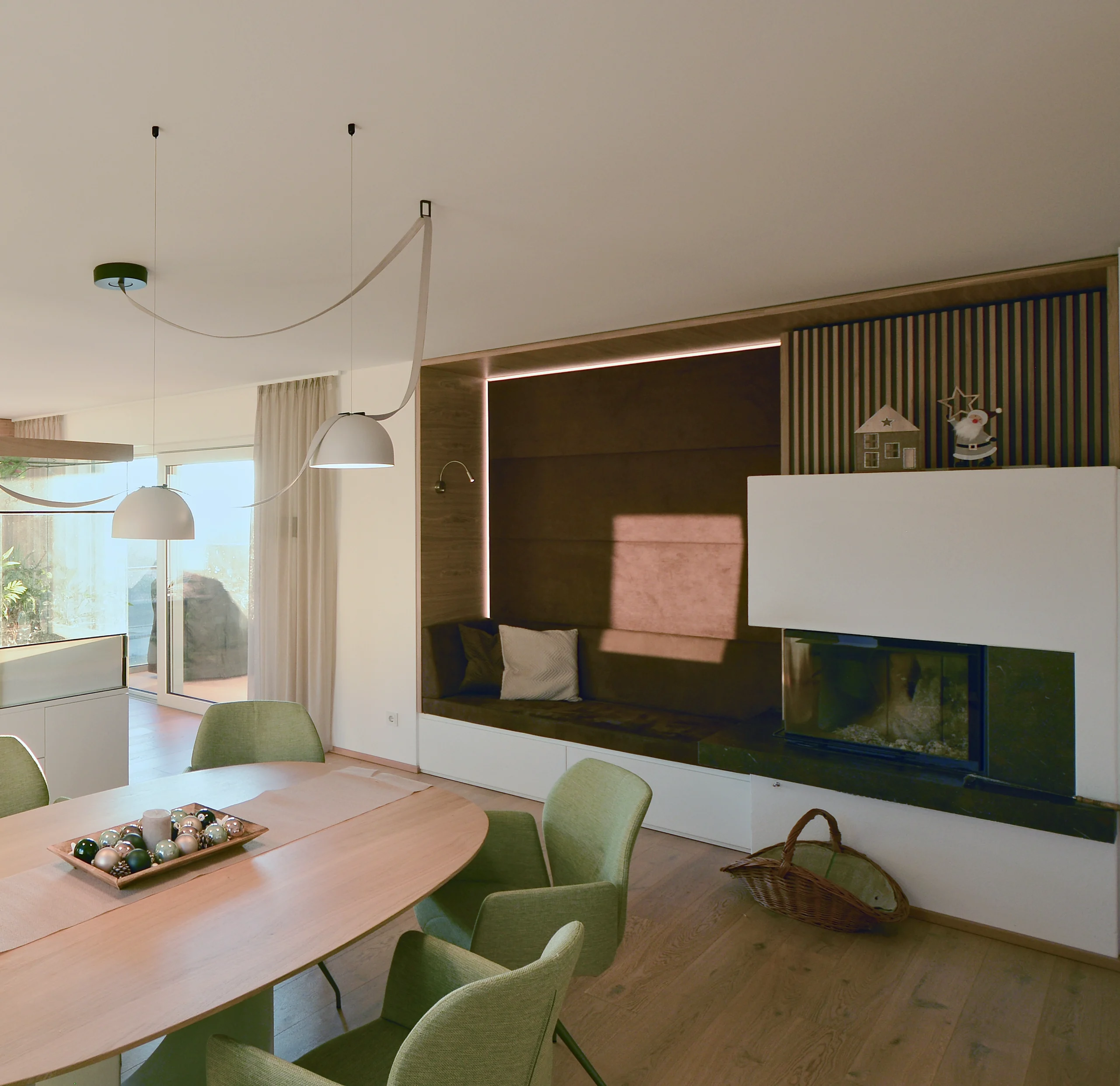 Wohnraumplanung: Essbereich mit ovalem Eichentisch, Sitznische mit Lichtfuge und Kamin, Pflanztrog mit Holzlamellen – geplant von ELIAS raumdesign