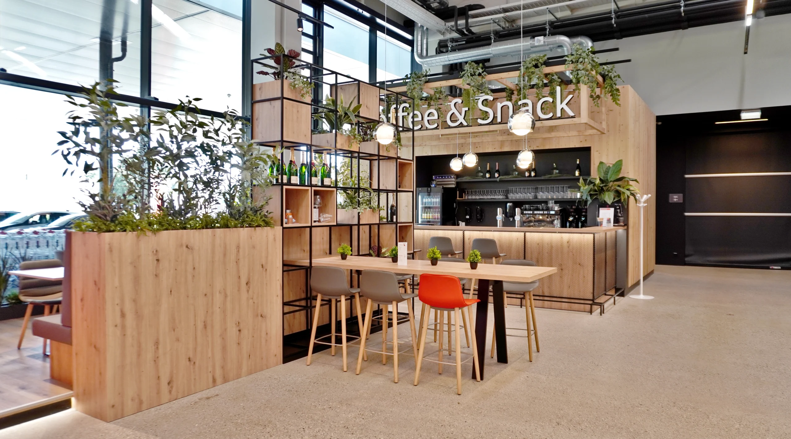 Ladenbau Transgourmet: Coffee- und Snackbar mit Holzverkleidung, Hochtischen und Pendelleuchten